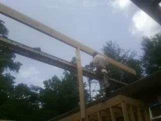 Carpenter setting a ridge beam over a new addition frame — Ice Dam Removal by Roofing Brothers in Fawn Grove