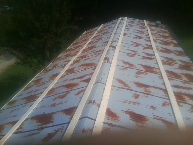 Rusted metal roof panels with new wood purlins before replacement — Storm Damage Roof Repair in Fawn Grove by Roofing Brothers