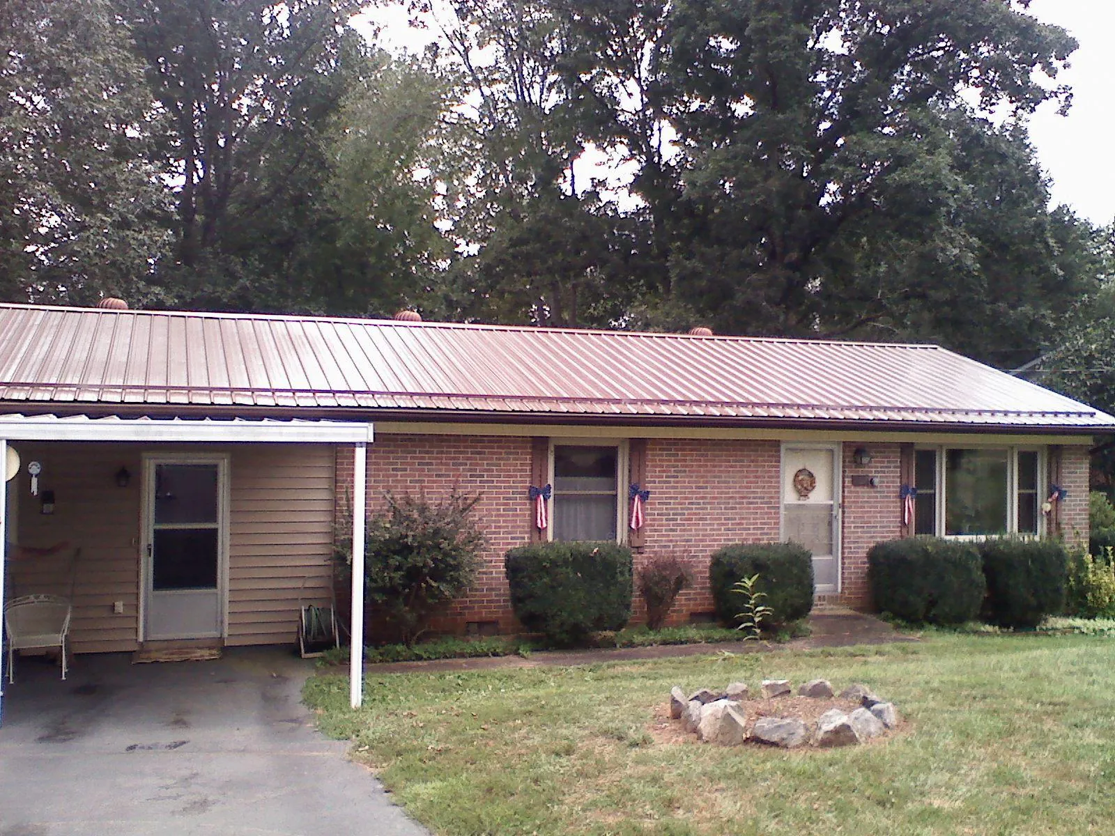 Bronze metal roof and carport on a brick ranch home — Roof Repair work by our crew in Fawn Grove